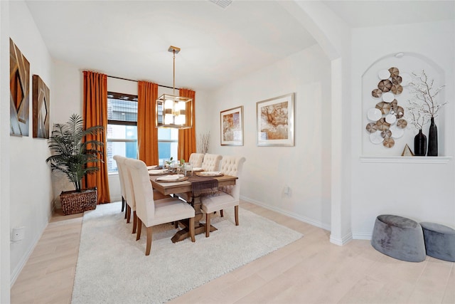 911 Bluewood St, Princeton, TX 75407 - dining space featuring arched walkways, light wood finished floors, baseboards, and a chandelier