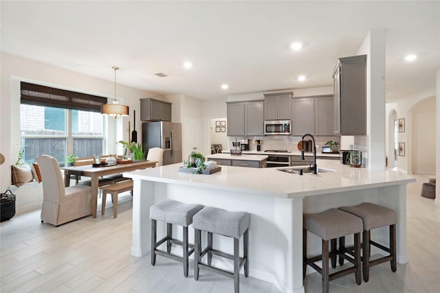 911 Bluewood St, Princeton, TX 75407 - kitchen with gray cabinetry, stainless steel appliances, a sink, a breakfast bar area, and recessed lighting