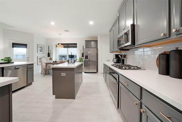 911 Bluewood St, Princeton, TX 75407 - kitchen with stainless steel appliances, tasteful backsplash, an island with sink, light countertops, and pendant lighting