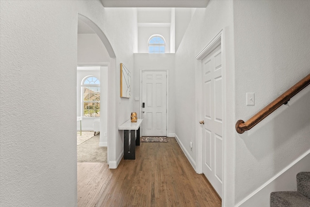 5653 Salt Springs Dr, Fort Worth, TX 76179 - entrance foyer featuring a textured wall, stairway, arched walkways, wood finished floors, and a high ceiling