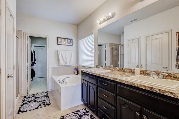 1300 Woodbine Cliff Dr, Fort Worth, TX 76179 - bathroom featuring a stall shower, double vanity, a bath, and tile patterned floors