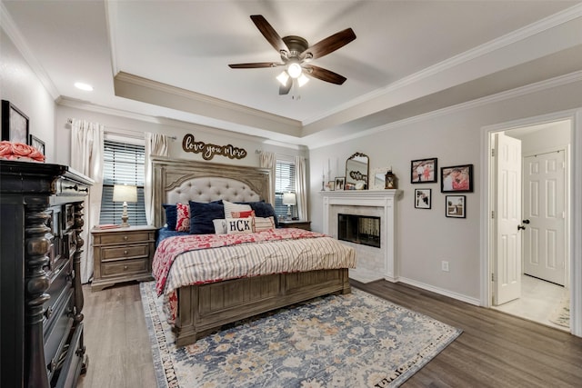 407 W Park Ave, Weatherford, TX 76086 - bedroom with a glass covered fireplace, a raised ceiling, wood finished floors, baseboards, and crown molding