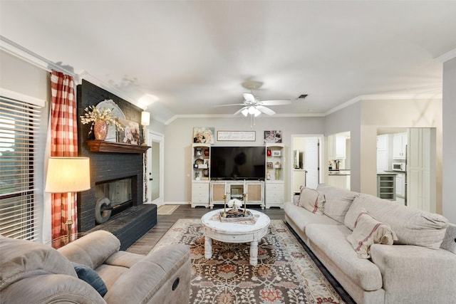 407 W Park Ave, Weatherford, TX 76086 - living area featuring wood finished floors, ornamental molding, a fireplace, a ceiling fan, and baseboards