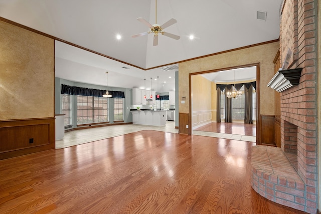 6808 N Oaks Dr, North Richland Hills, TX 76182 - unfurnished living room featuring crown molding, a chandelier, light wood-type flooring, a ceiling fan, and a wainscoted wall