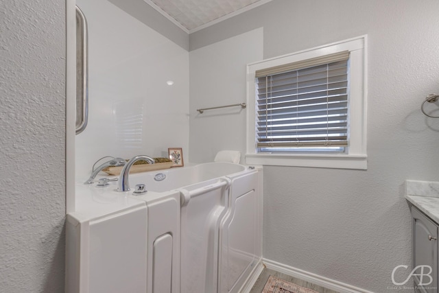 1126 Grand Ave, Abilene, TX 79605 - bathroom with a garden tub, vanity, crown molding, and a textured wall