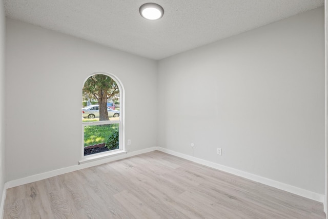 6206 Springwood Dr, Arlington, TX 76001 - unfurnished room with light wood finished floors, baseboards, and a textured ceiling