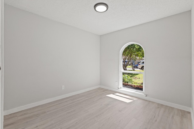 6206 Springwood Dr, Arlington, TX 76001 - spare room featuring wood finished floors, a textured ceiling, and baseboards