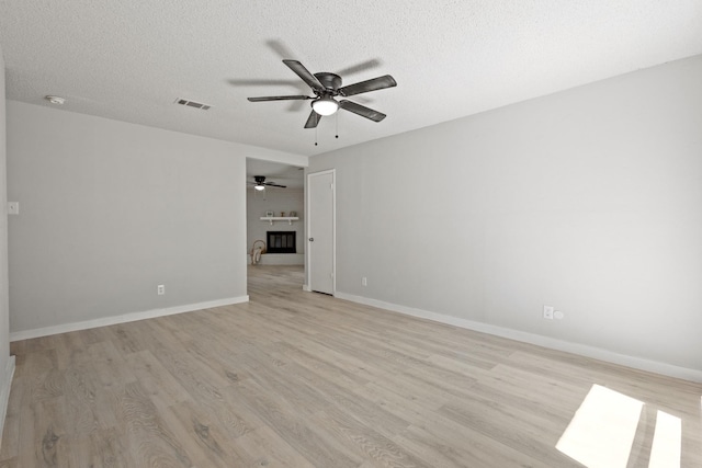 6206 Springwood Dr, Arlington, TX 76001 - spare room featuring a ceiling fan, light wood-style floors, a textured ceiling, and baseboards