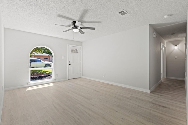 6206 Springwood Dr, Arlington, TX 76001 - unfurnished living room with ceiling fan, a textured ceiling, light wood finished floors, and baseboards