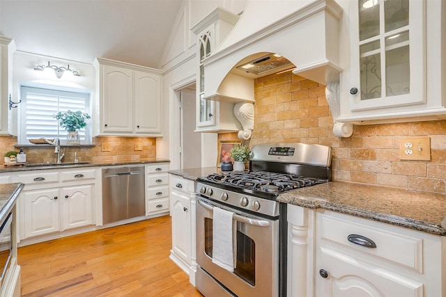 5800 Montford Dr, Colleyville, TX 76034 - kitchen featuring stainless steel appliances, a sink, white cabinetry, backsplash, and glass insert cabinets