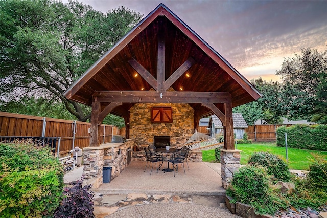 5800 Montford Dr, Colleyville, TX 76034 - fenced backyard with an outdoor stone fireplace, a patio area, and a gazebo