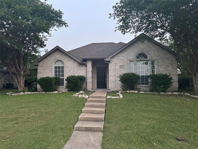 2977 Firewheel Dr, Rockwall, TX 75032 - view of front of home featuring a front lawn, brick siding, and central air condition unit