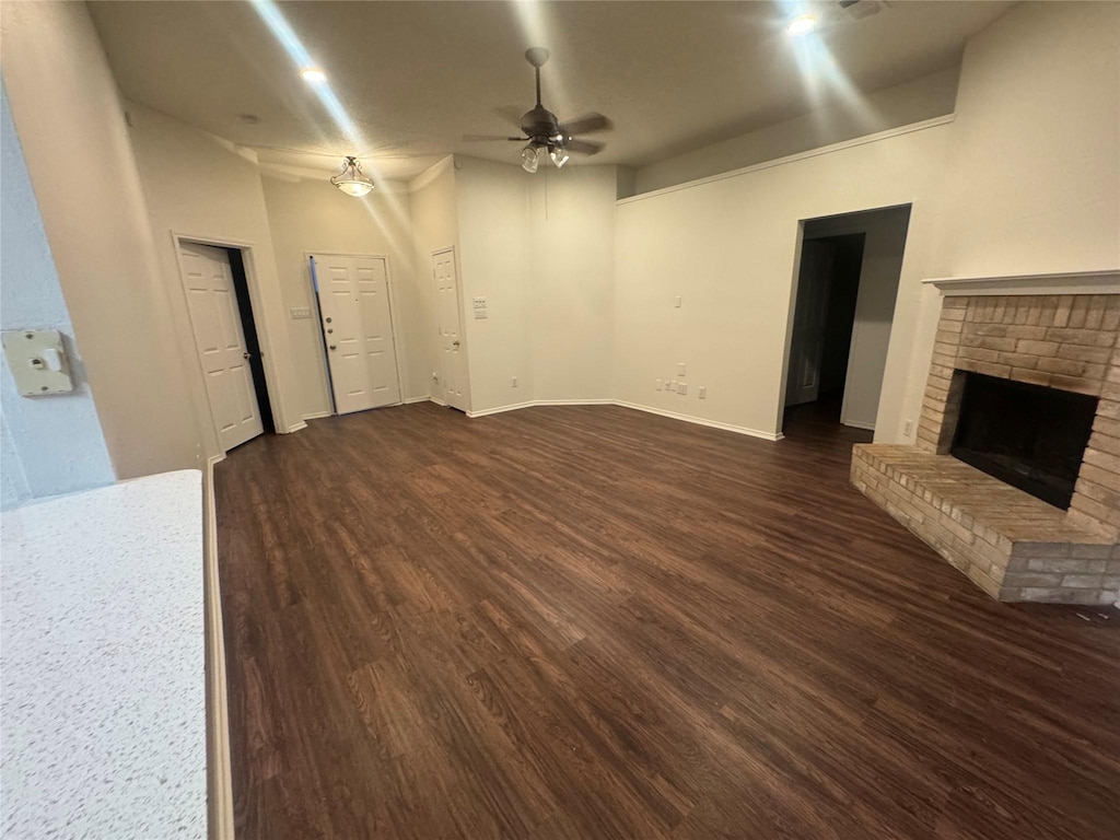 2977 Firewheel Dr, Rockwall, TX 75032 - unfurnished living room with ceiling fan, dark wood-type flooring, a fireplace, and baseboards