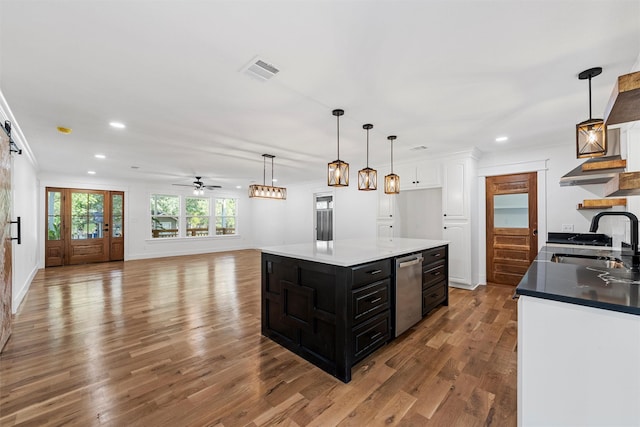 2925 Edmond Ave, Waco, TX 76707 - kitchen with dark cabinetry, a sink, recessed lighting, wood finished floors, and white cabinets