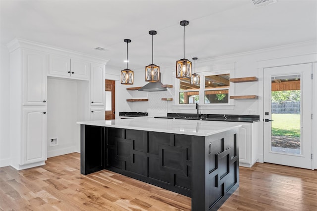 2925 Edmond Ave, Waco, TX 76707 - kitchen with open shelves, white cabinets, light wood-type flooring, decorative backsplash, and wall chimney range hood