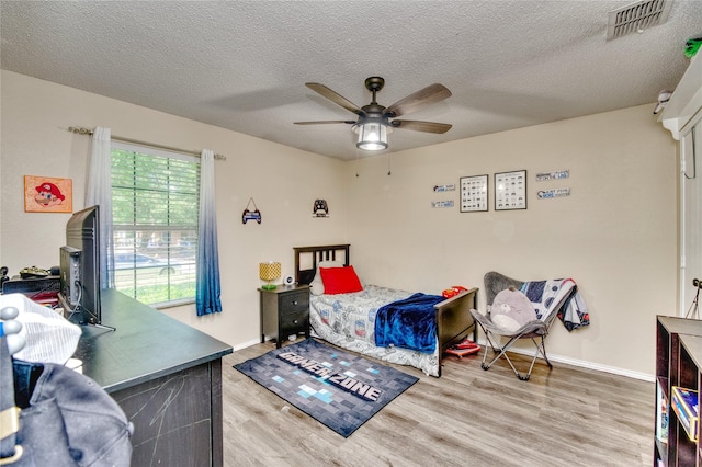 1209 Starpoint Ln, Wylie, TX 75098 - bedroom featuring wood finished floors, a textured ceiling, baseboards, and a ceiling fan