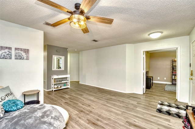 1209 Starpoint Ln, Wylie, TX 75098 - living area with light wood-style flooring, a textured ceiling, a ceiling fan, and baseboards