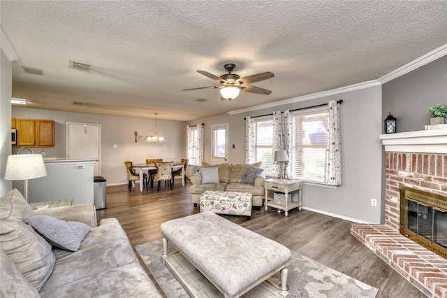 1209 Starpoint Ln, Wylie, TX 75098 - living area with crown molding, a textured ceiling, a ceiling fan, a brick fireplace, and a chandelier