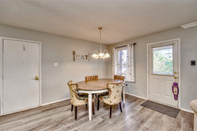 1209 Starpoint Ln, Wylie, TX 75098 - dining space featuring wood finished floors, a textured ceiling, a chandelier, and baseboards