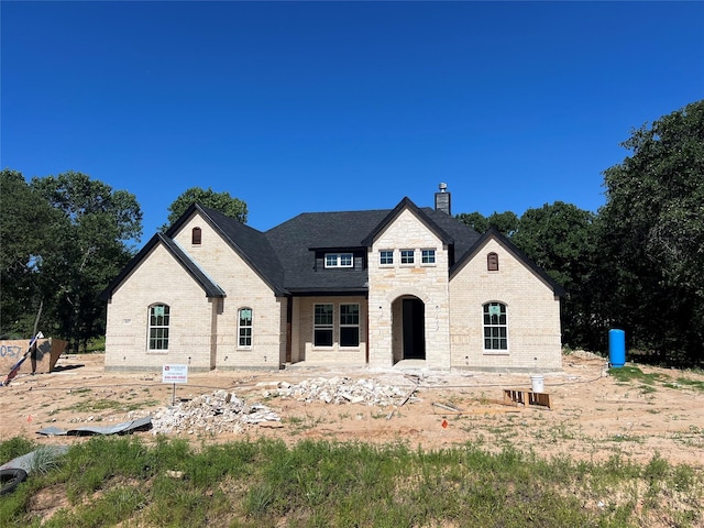1057 Llano Way, Poolville, TX 76487 - french country inspired facade featuring a chimney, stone siding, and brick siding