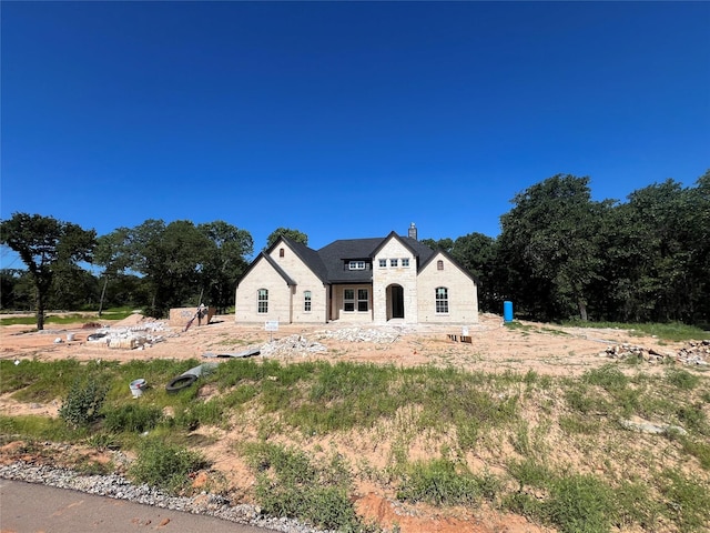 1057 Llano Way, Poolville, TX 76487 - french country inspired facade with a chimney and stone siding