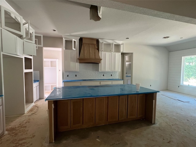 1057 Llano Way, Poolville, TX 76487 - kitchen with custom range hood, tasteful backsplash, a large island, and white cabinetry