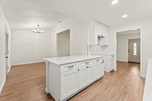 8810 Sugarberry Rd, Dallas, TX 75249 - kitchen with a chandelier, white cabinets, baseboards, light wood-style flooring, and recessed lighting