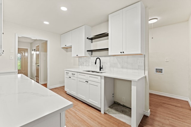8810 Sugarberry Rd, Dallas, TX 75249 - kitchen with a sink, tasteful backsplash, white cabinets, light wood-style floors, and recessed lighting