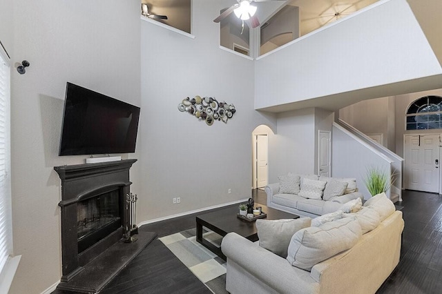 925 Lake Grove Dr, Little Elm, TX 75068 - living area with stairway, a high ceiling, wood finished floors, a glass covered fireplace, and a ceiling fan