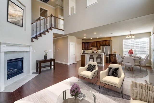 6101 Eagle Nest Dr, Garland, TX 75044 - living area with dark wood-style floors, a tiled fireplace, a chandelier, baseboards, and a high ceiling