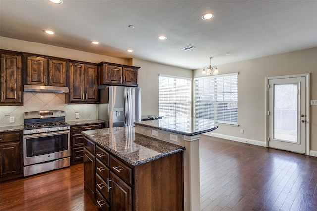 6101 Eagle Nest Dr, Garland, TX 75044 - kitchen with stainless steel appliances, a center island, a chandelier, under cabinet range hood, and tasteful backsplash
