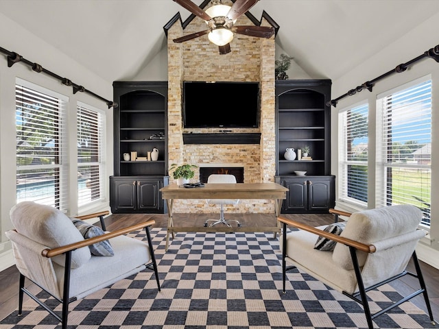 501 Las Lomas Dr, Heath, TX 75032 - living area featuring lofted ceiling, a ceiling fan, wood finished floors, a stone fireplace, and built in shelves