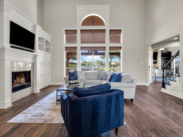 501 Las Lomas Dr, Heath, TX 75032 - living area with a high ceiling, stairs, a tile fireplace, and dark wood-type flooring