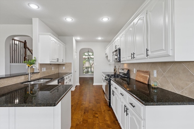 2256 Laurel Forest Dr, Fort Worth, TX 76177 - kitchen with stainless steel appliances, arched walkways, a sink, dark stone countertops, and recessed lighting