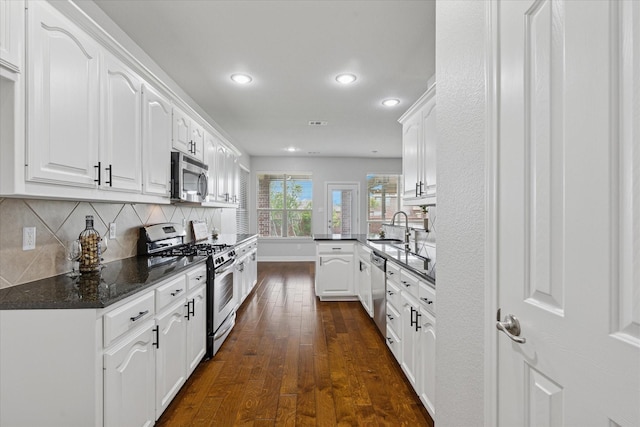 2256 Laurel Forest Dr, Fort Worth, TX 76177 - kitchen featuring stainless steel appliances, dark wood finished floors, a peninsula, a sink, and white cabinets