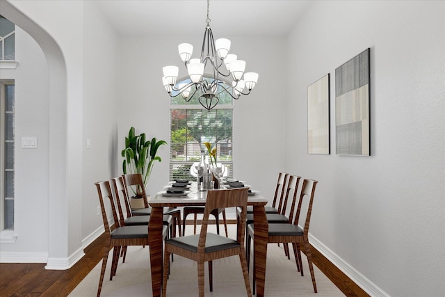 2256 Laurel Forest Dr, Fort Worth, TX 76177 - dining room featuring arched walkways, a chandelier, wood-type flooring, and baseboards