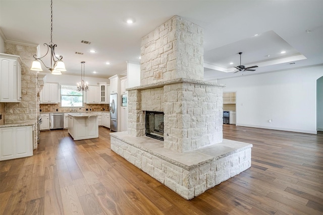 6005 Selkirk Ct, Cleburne, TX 76033 - unfurnished living room featuring a stone fireplace, a ceiling fan, ornamental molding, wood finished floors, and recessed lighting