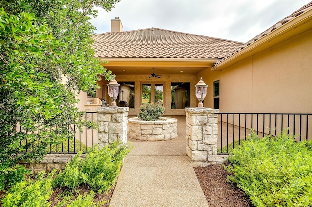 6005 Selkirk Ct, Cleburne, TX 76033 - view of exterior entry with a ceiling fan, stucco siding, a chimney, and a tile roof