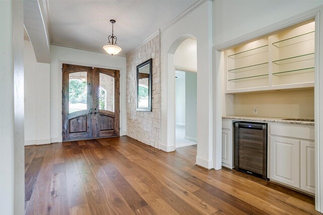 6005 Selkirk Ct, Cleburne, TX 76033 - foyer entrance with beverage cooler, arched walkways, french doors, crown molding, and a dry bar