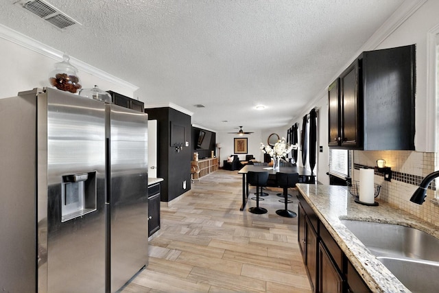 2908 Quail Run Dr, Mesquite, TX 75149 - kitchen featuring stainless steel refrigerator with ice dispenser, a sink, a textured ceiling, backsplash, and ceiling fan