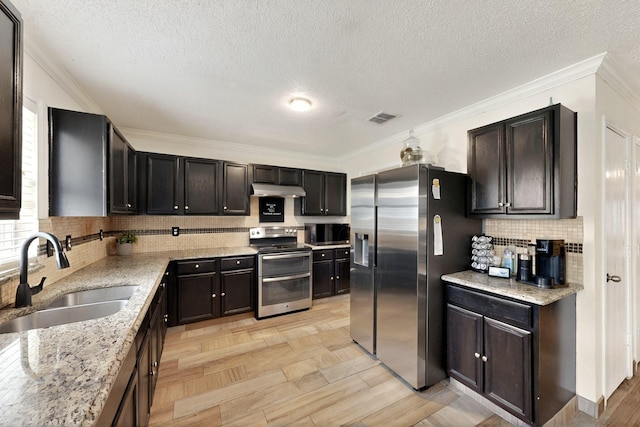 2908 Quail Run Dr, Mesquite, TX 75149 - kitchen featuring appliances with stainless steel finishes, a sink, under cabinet range hood, light stone countertops, and backsplash