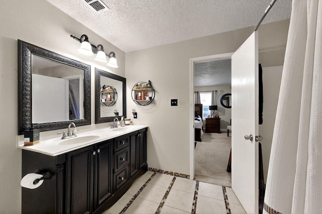 2908 Quail Run Dr, Mesquite, TX 75149 - bathroom featuring a textured ceiling, double vanity, and tile patterned floors