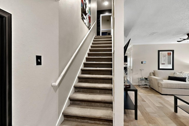 2908 Quail Run Dr, Mesquite, TX 75149 - stairway featuring a textured ceiling, wood finished floors, and ceiling fan