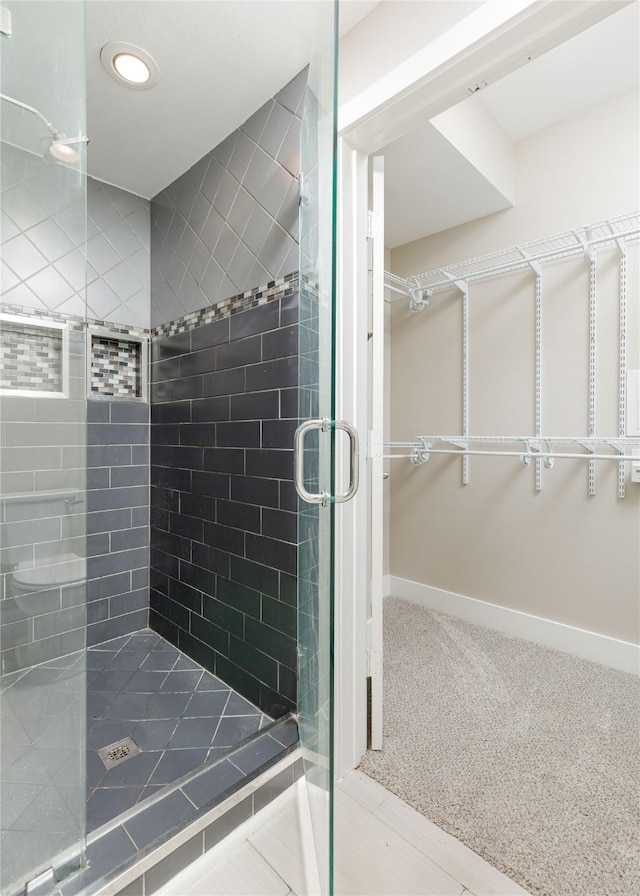 4605 Cedar Springs Rd Unit 201, Dallas, TX 75219 - full bathroom featuring a stall shower, a walk in closet, recessed lighting, and baseboards