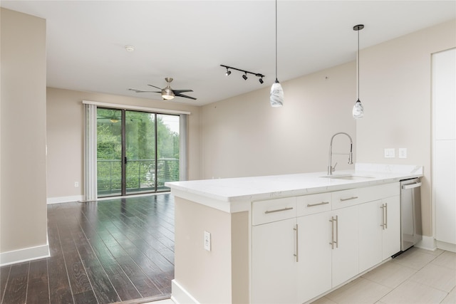 4605 Cedar Springs Rd Unit 201, Dallas, TX 75219 - kitchen with a sink, stainless steel dishwasher, a ceiling fan, a peninsula, and light stone counters