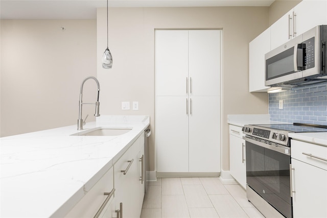 4605 Cedar Springs Rd Unit 201, Dallas, TX 75219 - kitchen with stainless steel appliances, a sink, light stone countertops, tasteful backsplash, and white cabinetry
