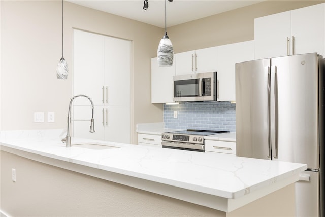 4605 Cedar Springs Rd Unit 201, Dallas, TX 75219 - kitchen featuring appliances with stainless steel finishes, a sink, a peninsula, tasteful backsplash, and hanging light fixtures