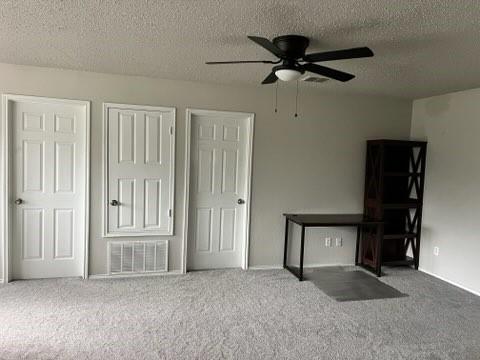 8412 Widgeon Way, Dallas, TX 75249 - unfurnished bedroom with carpet floors, a textured ceiling, and a ceiling fan