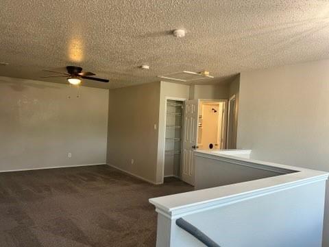 8412 Widgeon Way, Dallas, TX 75249 - spare room featuring dark colored carpet, ceiling fan, and a textured ceiling