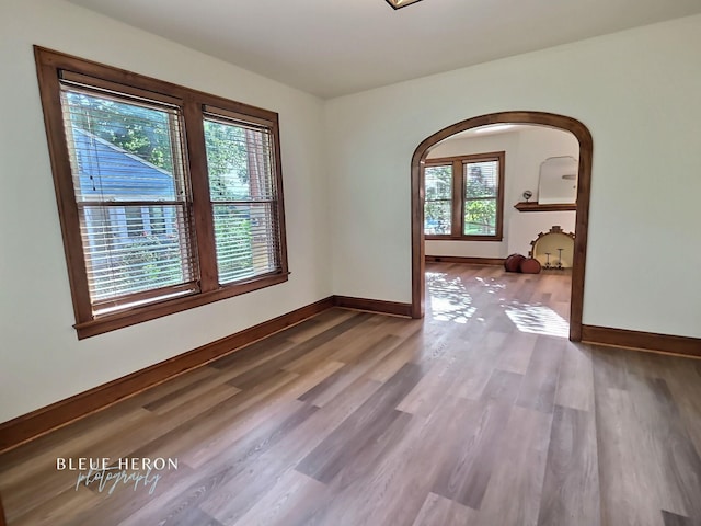 129 Ardmore Ave, Shreveport, LA 71105 - spare room featuring healthy amount of natural light, arched walkways, wood finished floors, and baseboards
